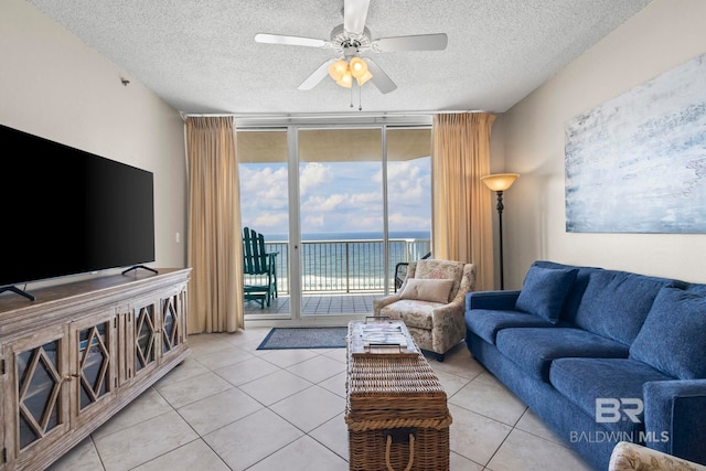 527 Beach Club Trl Unit C908, Gulf Shores, AL 36542 - living area with a textured ceiling, a water view, tile patterned floors, expansive windows, and a ceiling fan