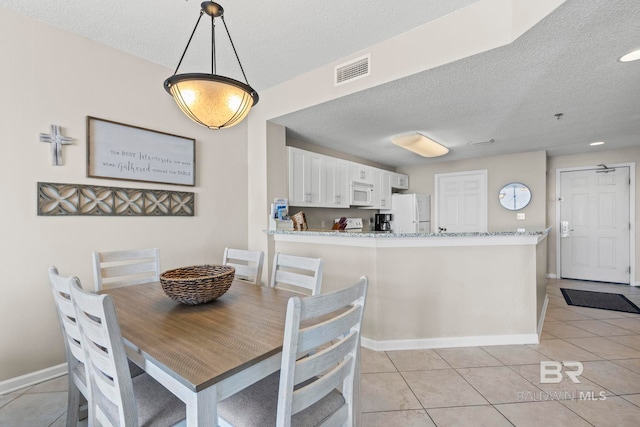 527 Beach Club Trl Unit C908, Gulf Shores, AL 36542 - dining space featuring baseboards, light tile patterned flooring, a textured ceiling, and visible vents