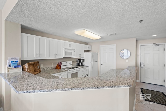 527 Beach Club Trl Unit C908, Gulf Shores, AL 36542 - kitchen featuring white appliances, a peninsula, light stone counters, and light tile patterned flooring