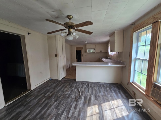 206 E Granberry St, Brewton, AL 36426 - kitchen with a ceiling fan, a peninsula, white microwave, and dark wood-type flooring