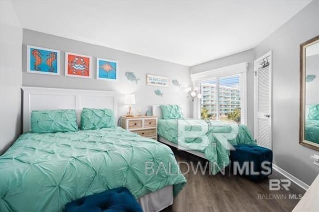 bedroom featuring baseboards and wood finished floors