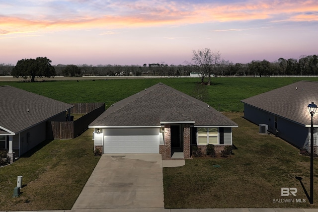 view of front facade featuring roof with shingles, brick siding, fence, a garage, and driveway