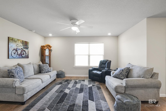 living room featuring a ceiling fan, dark wood finished floors, a textured ceiling, and baseboards