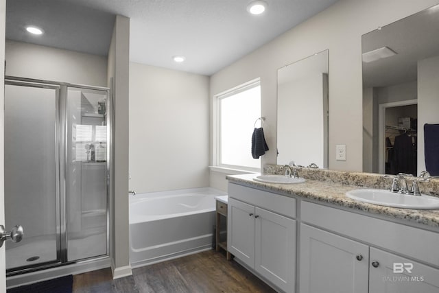 bathroom with a bath, a stall shower, and a sink