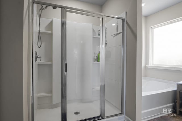 bathroom with a stall shower and a bath