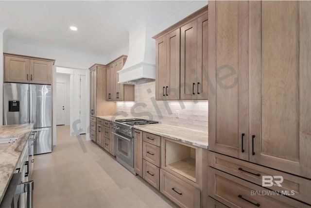 kitchen featuring premium range hood, backsplash, light stone countertops, and appliances with stainless steel finishes