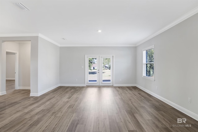 1061 Tampa Ave, Foley, AL 36535 - empty room with plenty of natural light, wood finished floors, baseboards, ornamental molding, and french doors