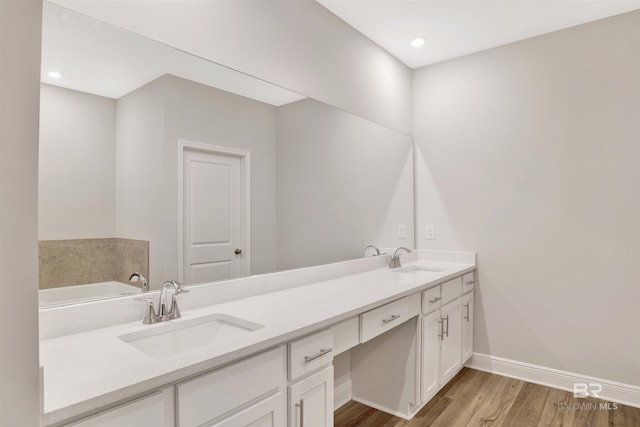 1061 Tampa Ave, Foley, AL 36535 - full bathroom with wood finished floors, baseboards, double vanity, recessed lighting, and a bathtub