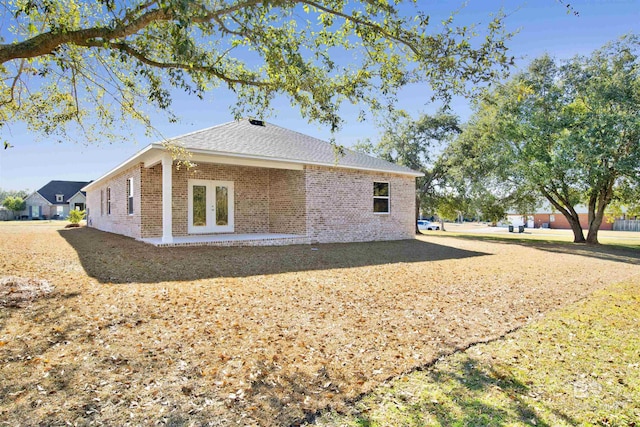 1061 Tampa Ave, Foley, AL 36535 - view of side of home featuring french doors, brick siding, and a shingled roof