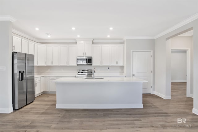 1061 Tampa Ave, Foley, AL 36535 - kitchen featuring stainless steel appliances, light countertops, a sink, a kitchen island with sink, and white cabinetry