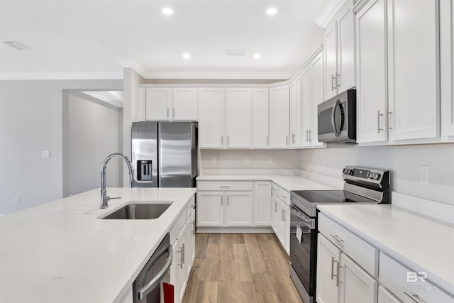 1061 Tampa Ave, Foley, AL 36535 - kitchen with appliances with stainless steel finishes, a sink, crown molding, white cabinets, and light wood finished floors