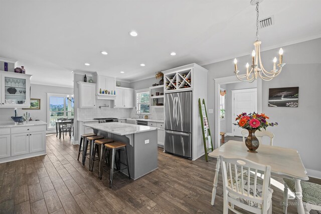 kitchen featuring tasteful backsplash, dark wood finished floors, ornamental molding, appliances with stainless steel finishes, and open shelves