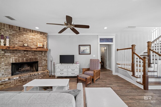 living area with visible vents, a brick fireplace, stairway, recessed lighting, and wood finished floors