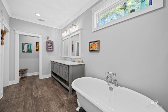 bathroom with vanity, wood finished floors, visible vents, a soaking tub, and ornamental molding