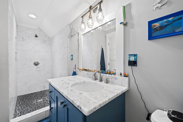 full bath featuring vanity, vaulted ceiling, toilet, and a tile shower