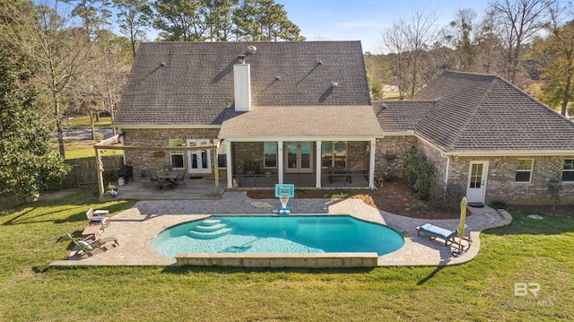 back of property with a patio, french doors, a lawn, and a chimney