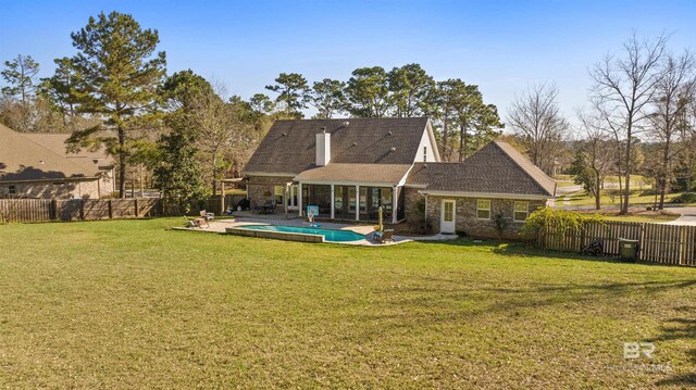 rear view of house with a yard, a fenced backyard, and a fenced in pool