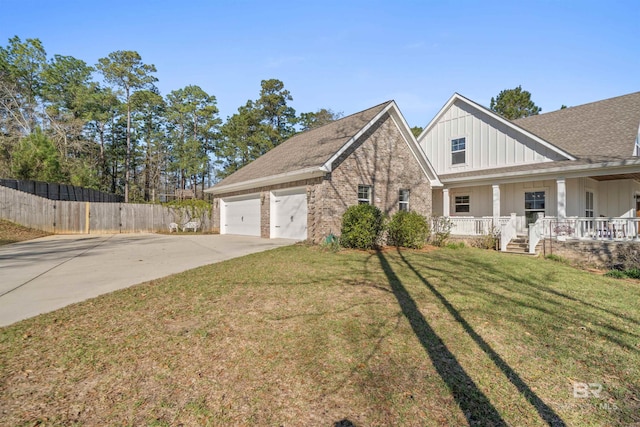 view of front facade featuring brick siding, a front lawn, fence, a porch, and driveway