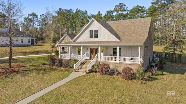 view of front of home with a front lawn, fence, stairway, french doors, and covered porch