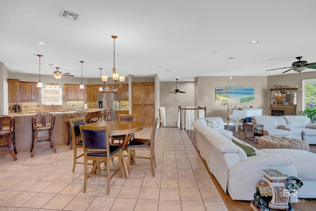 dining room featuring a ceiling fan, visible vents, and light tile patterned floors