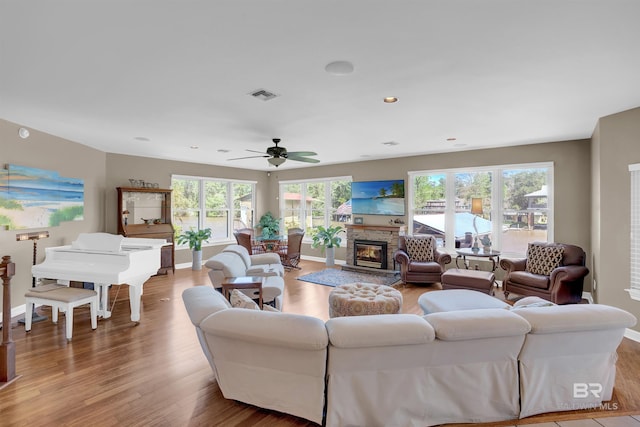 living area featuring baseboards, wood finished floors, and visible vents
