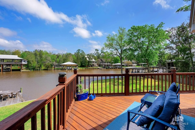 wooden deck with a water view and a yard