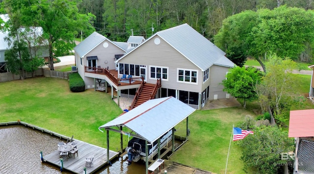 back of property featuring fence, a deck with water view, boat lift, stairway, and a forest view