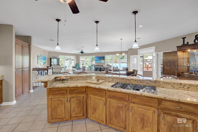 kitchen with open floor plan, ceiling fan, light tile patterned floors, and stainless steel gas stovetop