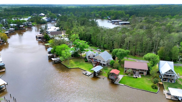 drone / aerial view featuring a water view, a view of trees, and a residential view