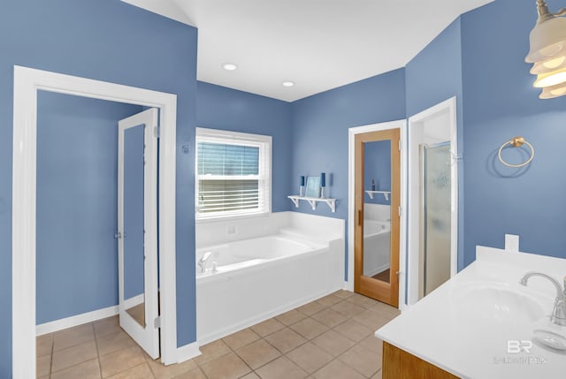 bathroom featuring tile patterned flooring, vanity, a garden tub, and a shower stall