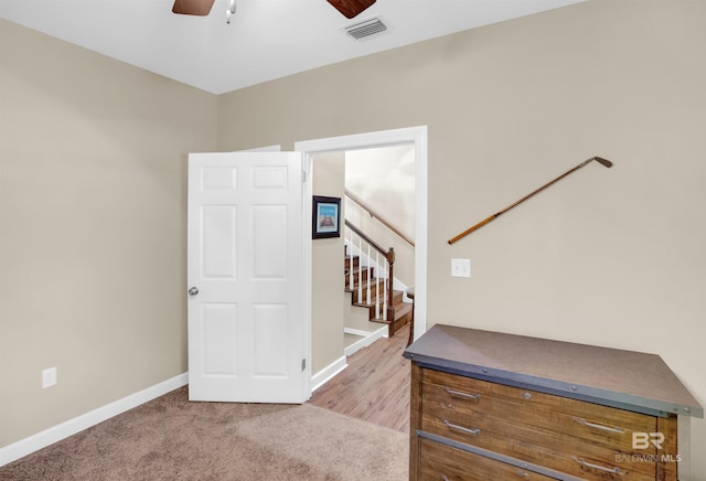 interior space with baseboards, ceiling fan, stairs, and visible vents