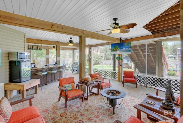 sunroom / solarium featuring plenty of natural light, ceiling fan, and an outdoor fire pit