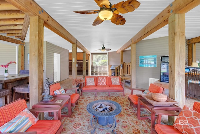sunroom / solarium featuring beamed ceiling, a ceiling fan, and an outdoor living space with a fire pit