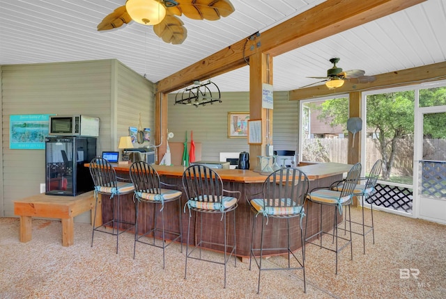 exterior space with ceiling fan, black refrigerator, and a wealth of natural light