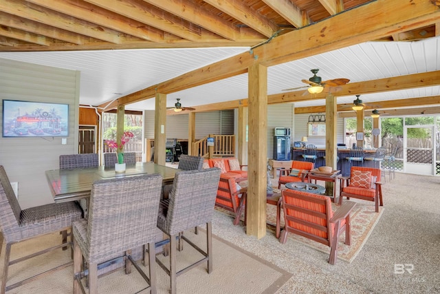 dining area featuring ceiling fan, carpet flooring, and beam ceiling