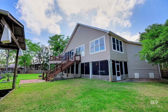 back of house with a wooden deck, fence, a sunroom, a yard, and stairway