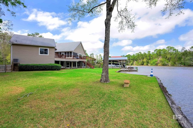 view of yard featuring stairs, a deck with water view, and a dock