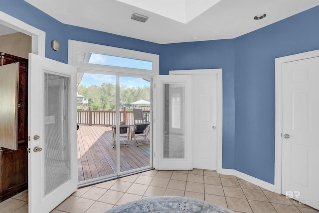 doorway to outside with baseboards, light tile patterned flooring, and visible vents
