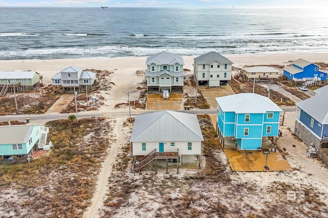 birds eye view of property with a water view and a beach view