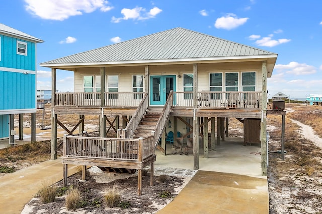 rear view of property with french doors, a carport, and covered porch