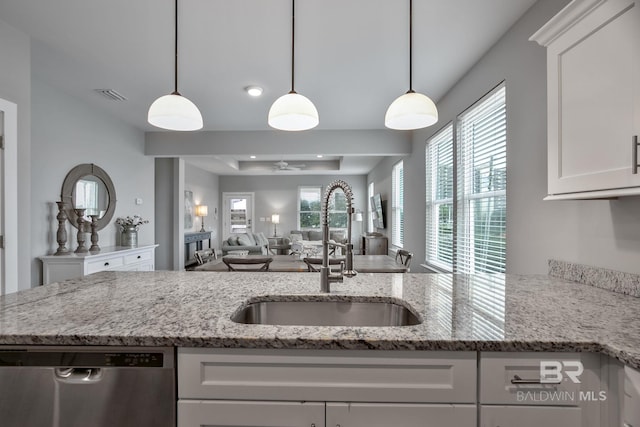 kitchen with white cabinetry, sink, light stone countertops, and dishwasher