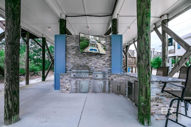 view of patio / terrace with an outdoor wet bar, grilling area, and exterior kitchen