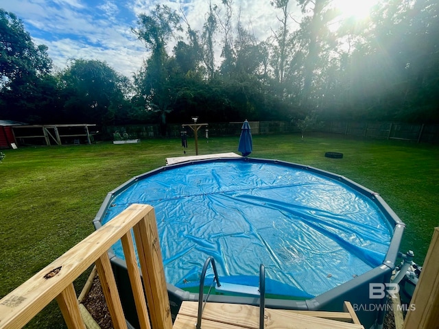 view of pool with a yard