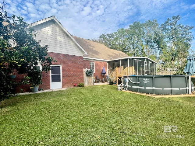 back of house featuring a yard and a sunroom