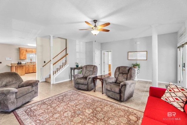 living room featuring ceiling fan, light tile patterned floors, sink, and decorative columns