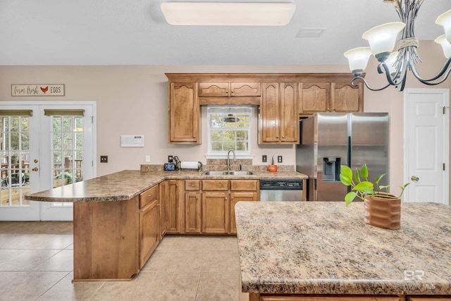 kitchen featuring stainless steel appliances, an inviting chandelier, plenty of natural light, and sink