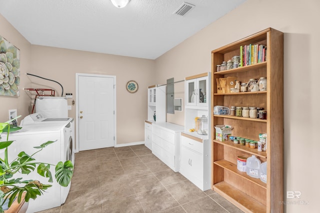 clothes washing area with light tile patterned flooring, gas water heater, separate washer and dryer, and a textured ceiling