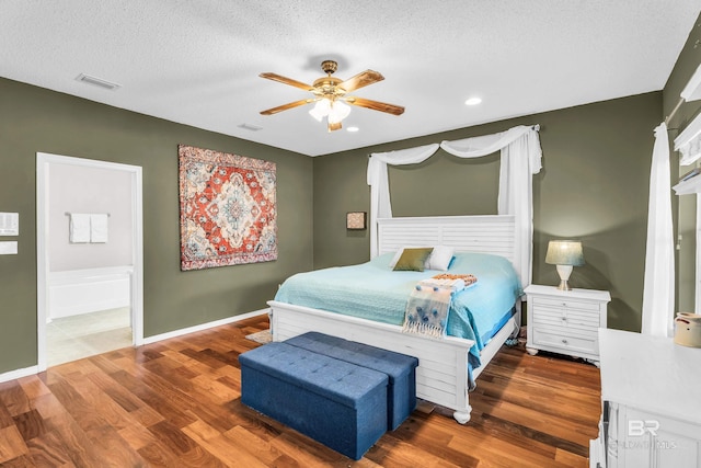 bedroom with ceiling fan, dark hardwood / wood-style flooring, and a textured ceiling