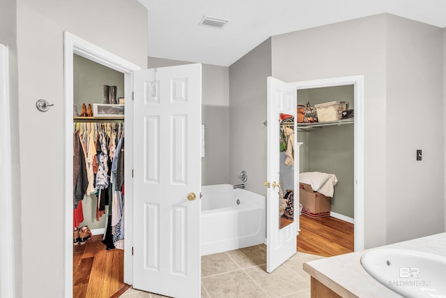 bathroom with hardwood / wood-style floors, vanity, and a bathtub