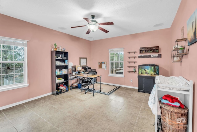 office featuring ceiling fan, light tile patterned floors, and a textured ceiling